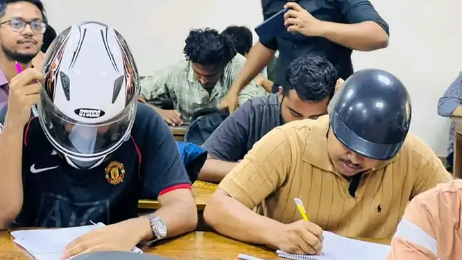 হেলমেট পরে ক্লাসে দুই শিক্ষার্থী, কেন জানেন?